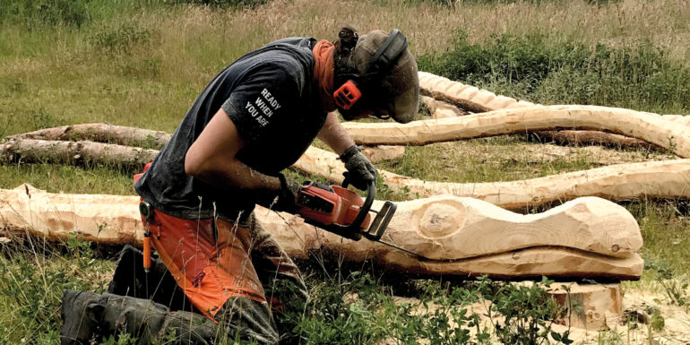 Billede af mand med motorsav der skærer en skulptur ud i træ